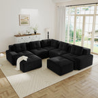 Black corduroy V-shaped 5-seater sectional sofa with tufted cushions, pearl-like piping, and two movable ottomans.