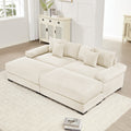 Oversized cream corduroy modular sectional sofa with deep seats, wide armrests, and matching ottoman in a bright room.