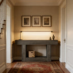 Modern rustic dark gray wood console table with a thick frame and lower shelf, positioned in a warmly lit entryway.