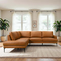 Modern left-facing sectional sofa in tan vegan leather with slim black metal legs, set in a bright, minimalist room.
