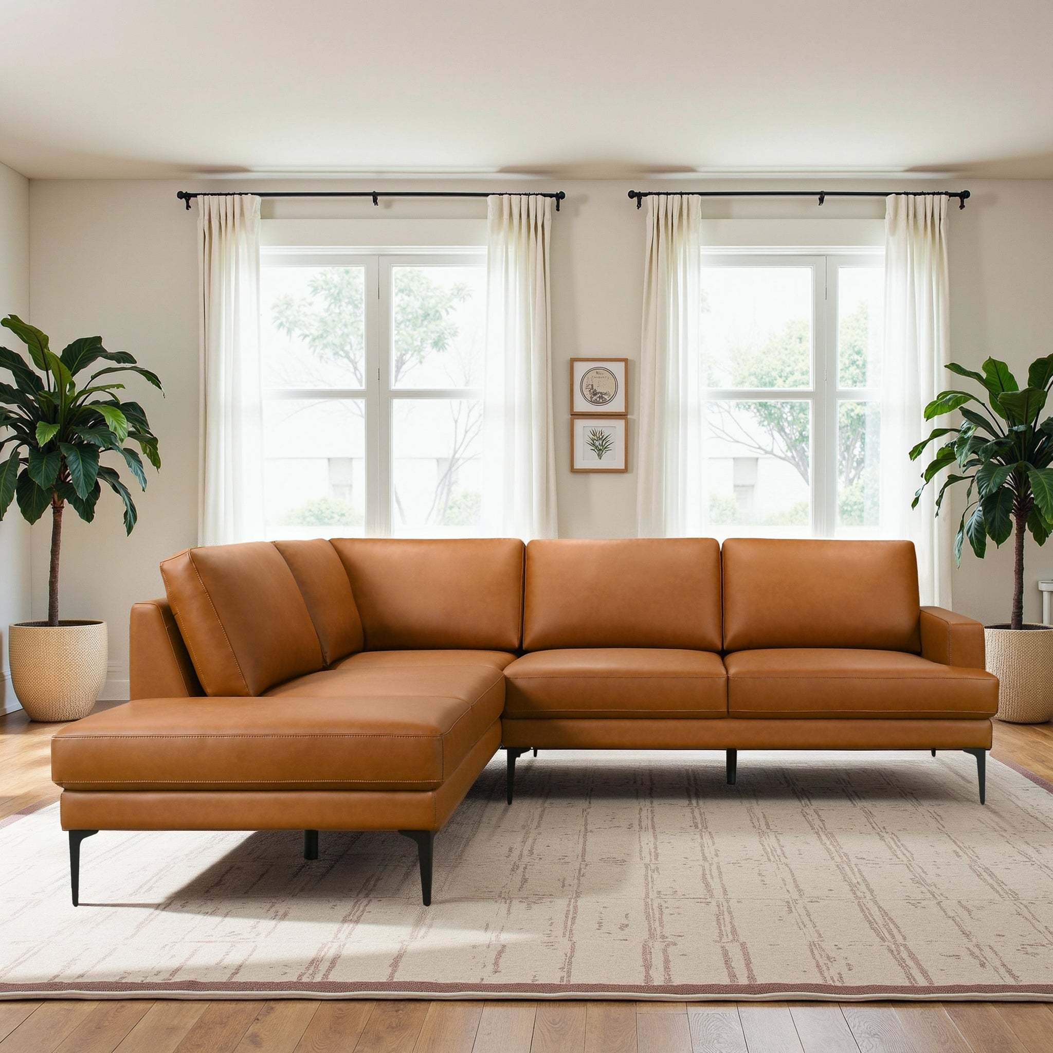 Modern left-facing sectional sofa in tan vegan leather with slim black metal legs, set in a bright, minimalist room.