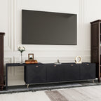 Contemporary black TV console with sleek design and ample storage, placed under a wall-mounted TV in a classic white-paneled room.