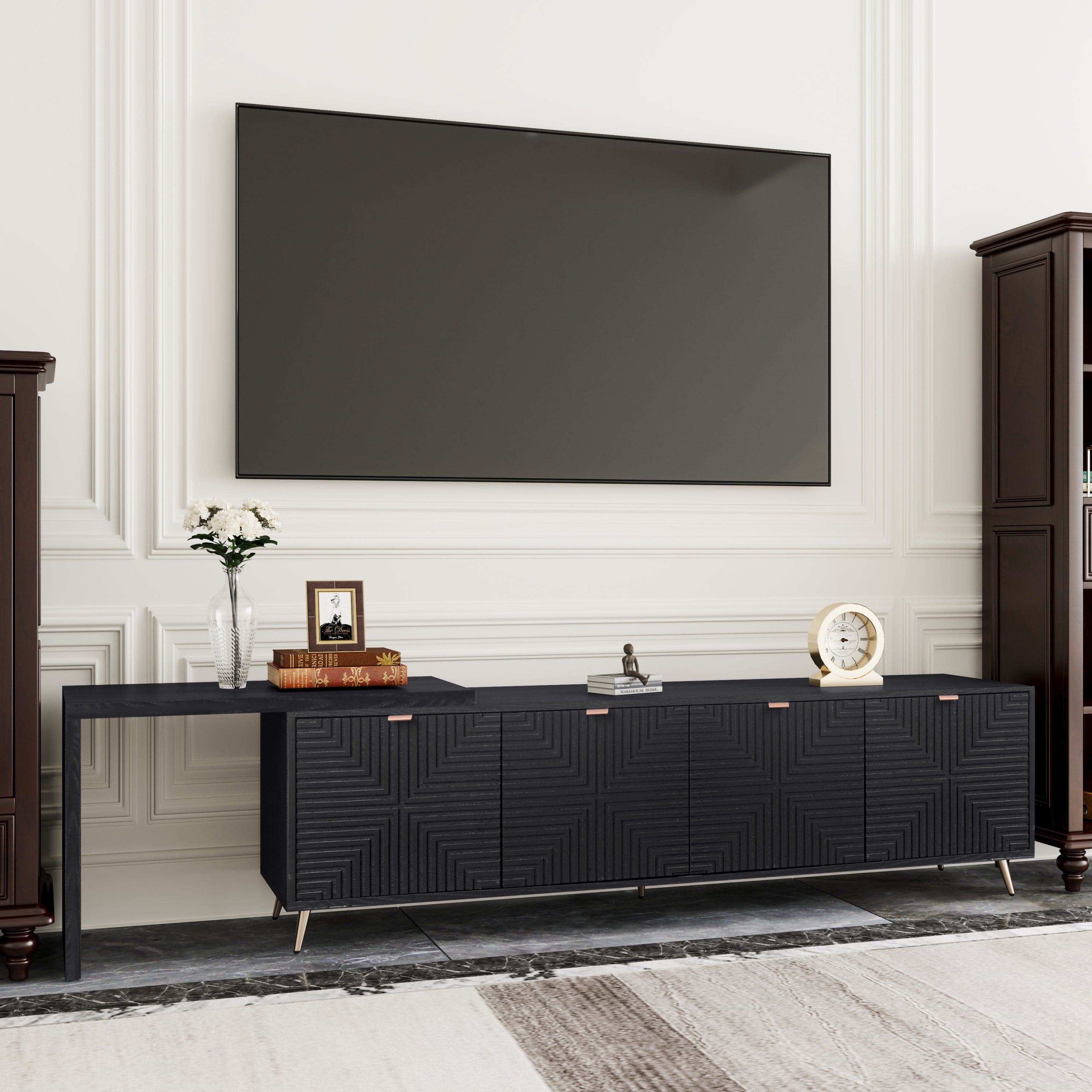 Contemporary black TV console with sleek design and ample storage, placed under a wall-mounted TV in a classic white-paneled room.