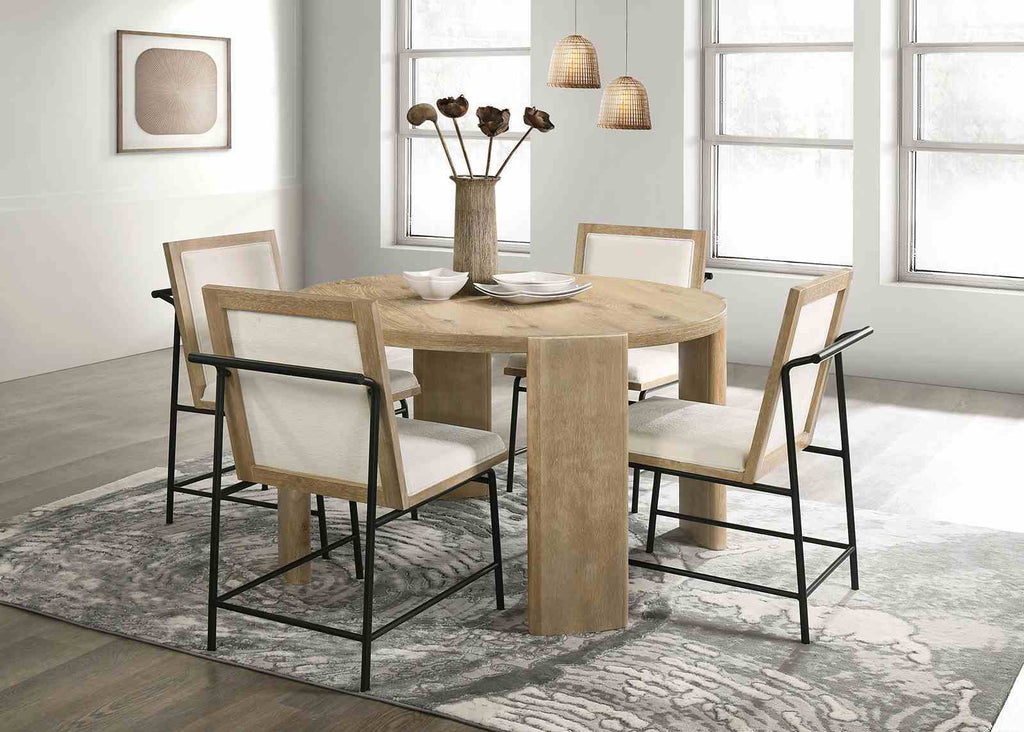 Set of four Oak Beige Dining Chairs around a round wood dining table in a bright, modern room with large windows and pendant lighting.