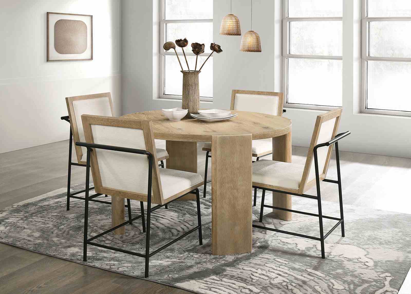 Set of four Oak Beige Dining Chairs around a round wood dining table in a bright, modern room with large windows and pendant lighting.