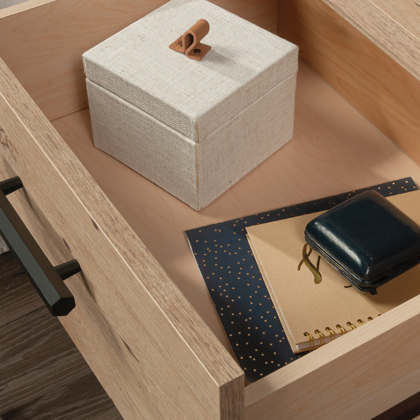 Interior view of the night stand drawer containing a fabric box and notebooks, showing spacious storage and smooth drawer lining.