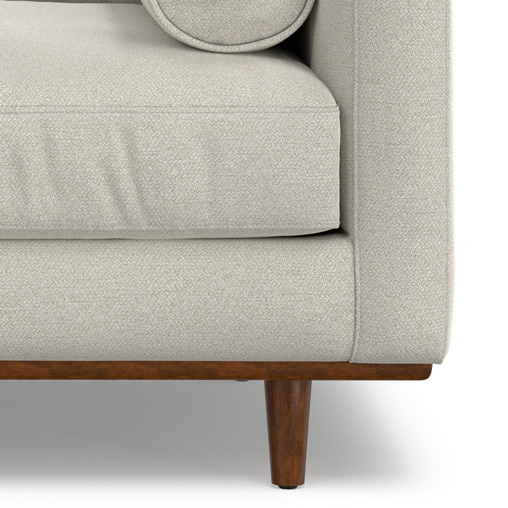 Lower front corner of Modern Armchair Cream White - Morrison Collection showing cushion seam and tapered wood leg.