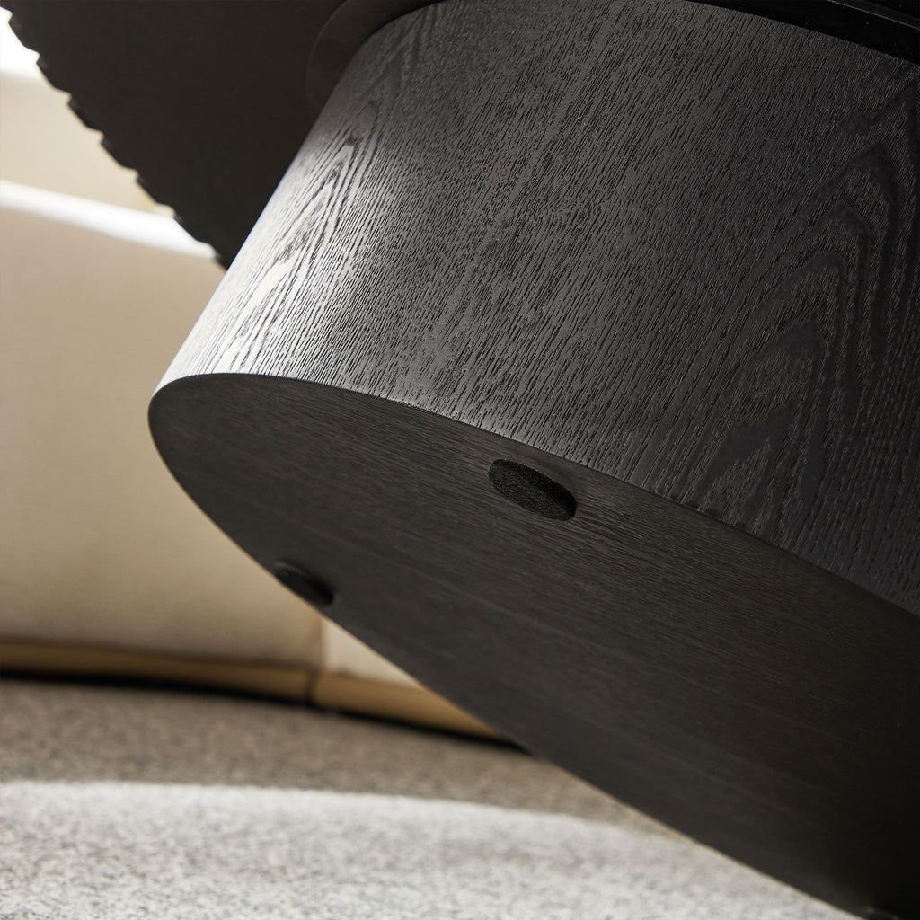 Close-up of the sturdy black cylindrical base of the modern round coffee table, showcasing durable wood texture and craftsmanship.