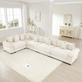 Oversized cream corduroy modular sectional sofa with deep seating, wide arms, and numerous matching throw pillows.