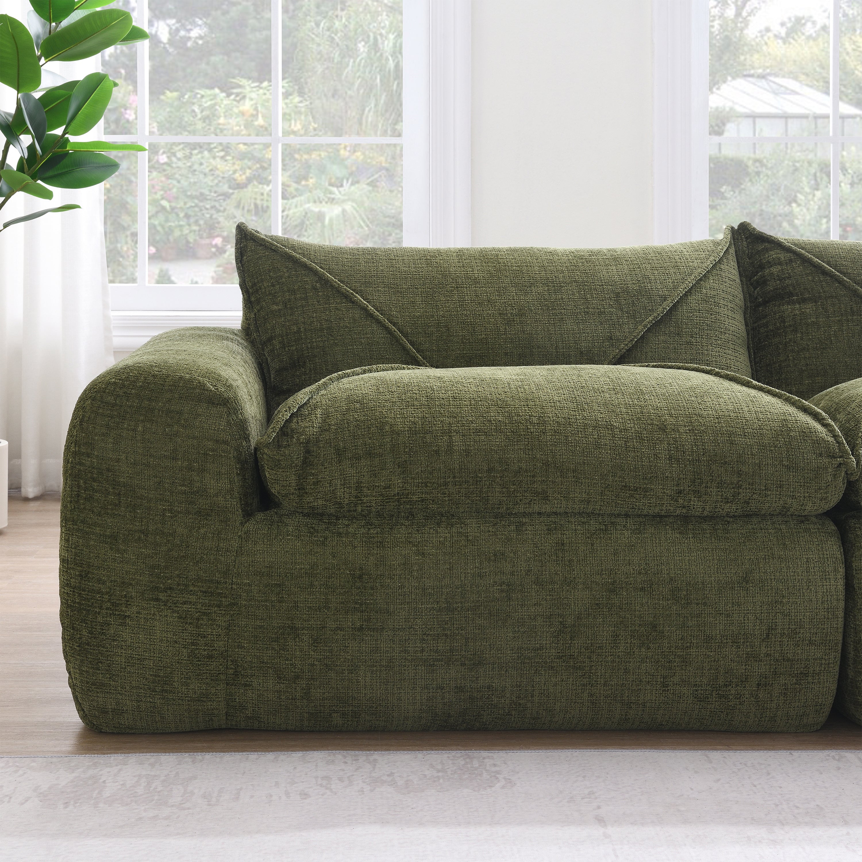 Detail of single seat on 116'' compressed sofa in green, emphasizing plush high density foam and soft, durable upholstery.