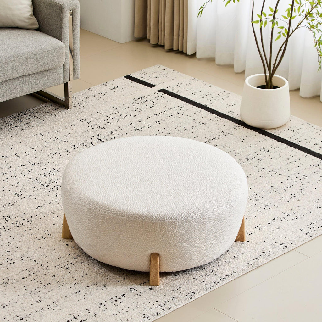 Modish Round Ottoman with Boucle Top and Natural Wood Legs.