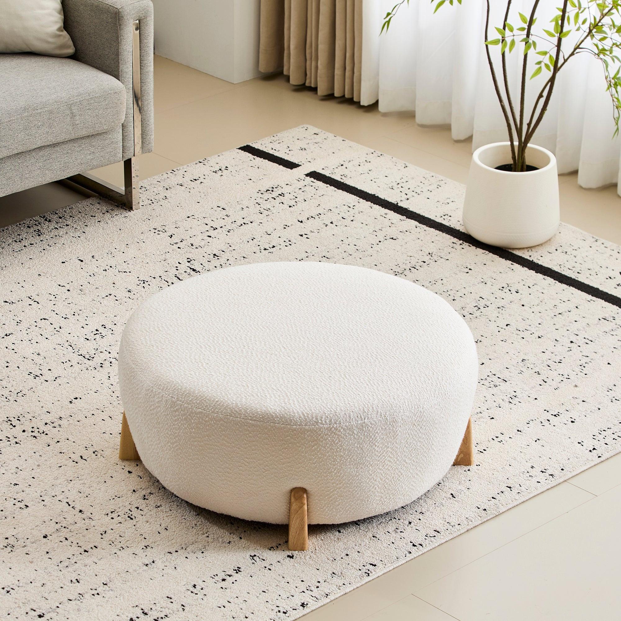 Modish Round Ottoman with Boucle Top and Natural Wood Legs.