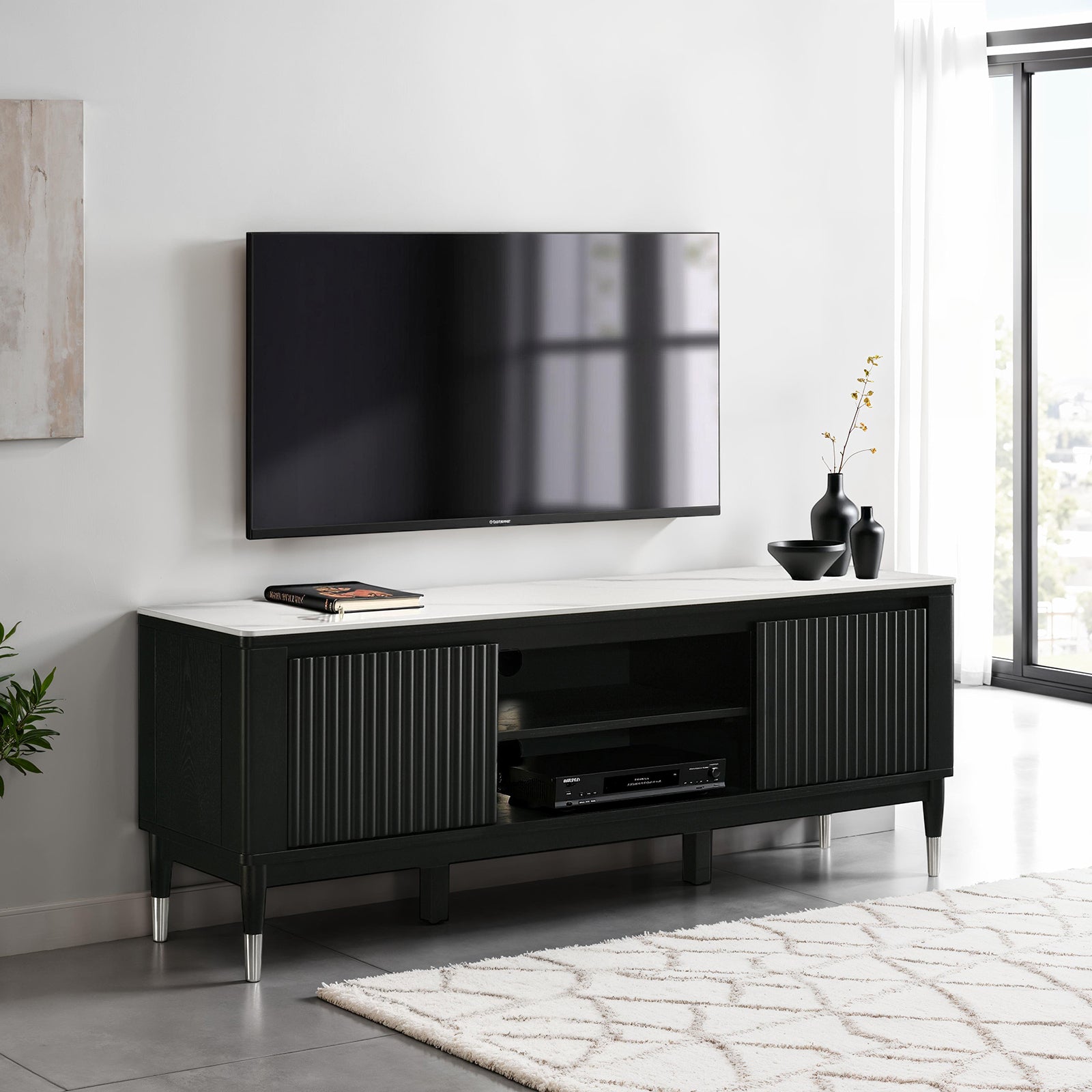 Contemporary TV Console with sintered stone top and silver-capped legs in modern living room. Features open shelves and fluted cabinet doors.