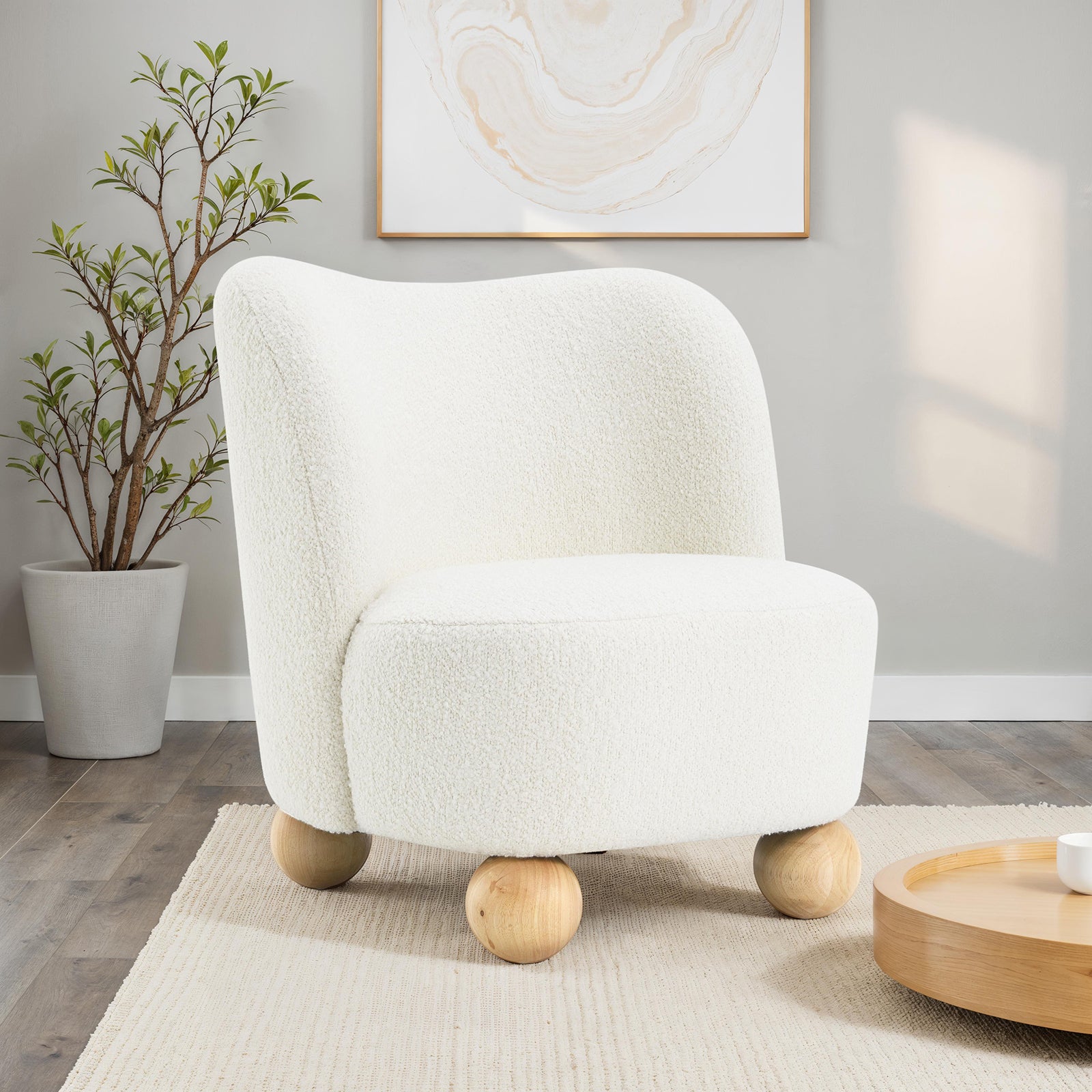 Boucle Upholstered Accent Chair with Curved Back in modern living room, featuring sculptural wooden ball feet and soft white boucle fabric.