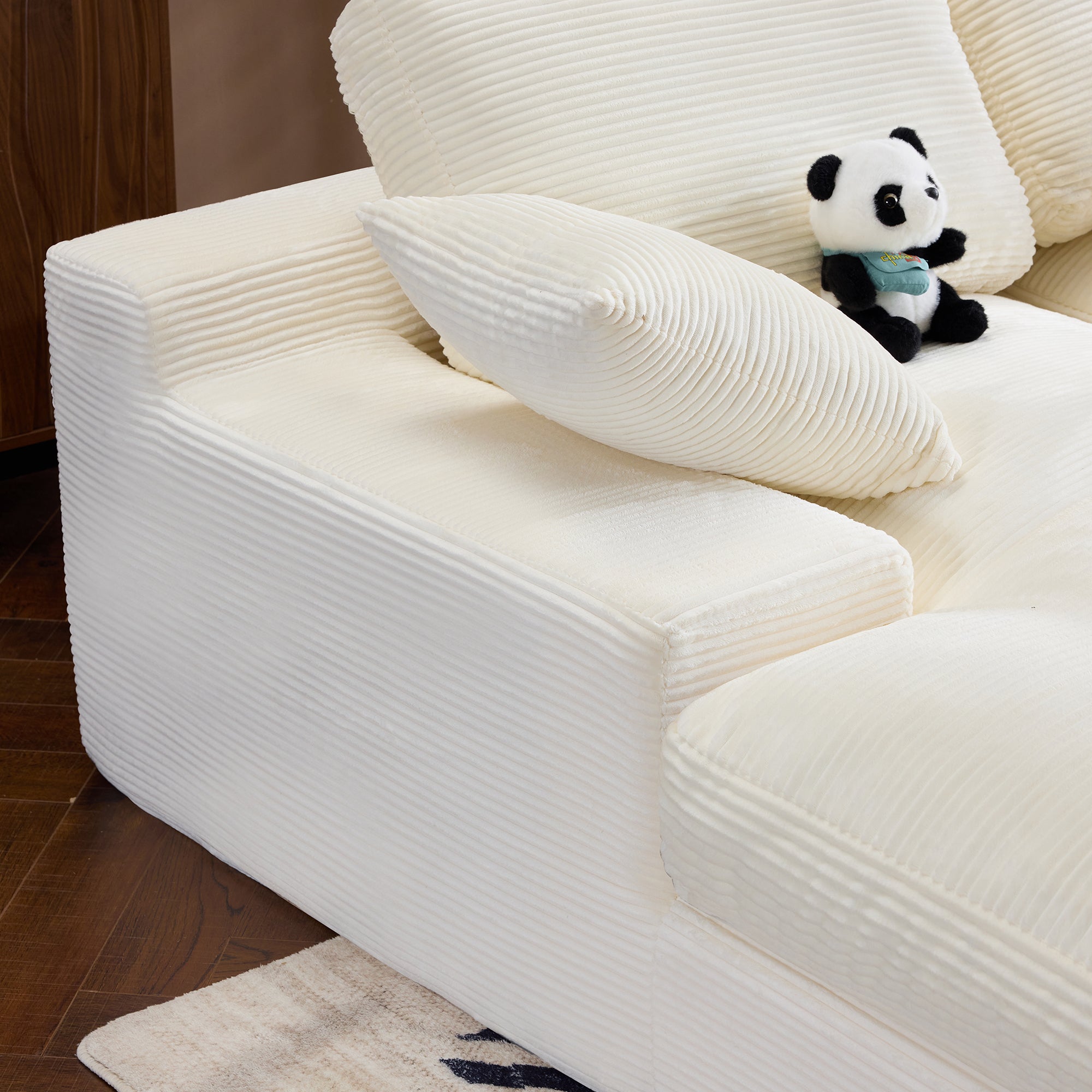 Armrest and pillow detail of Compressed Corduroy Sofa in white, showcasing soft ribbed fabric and supportive design.