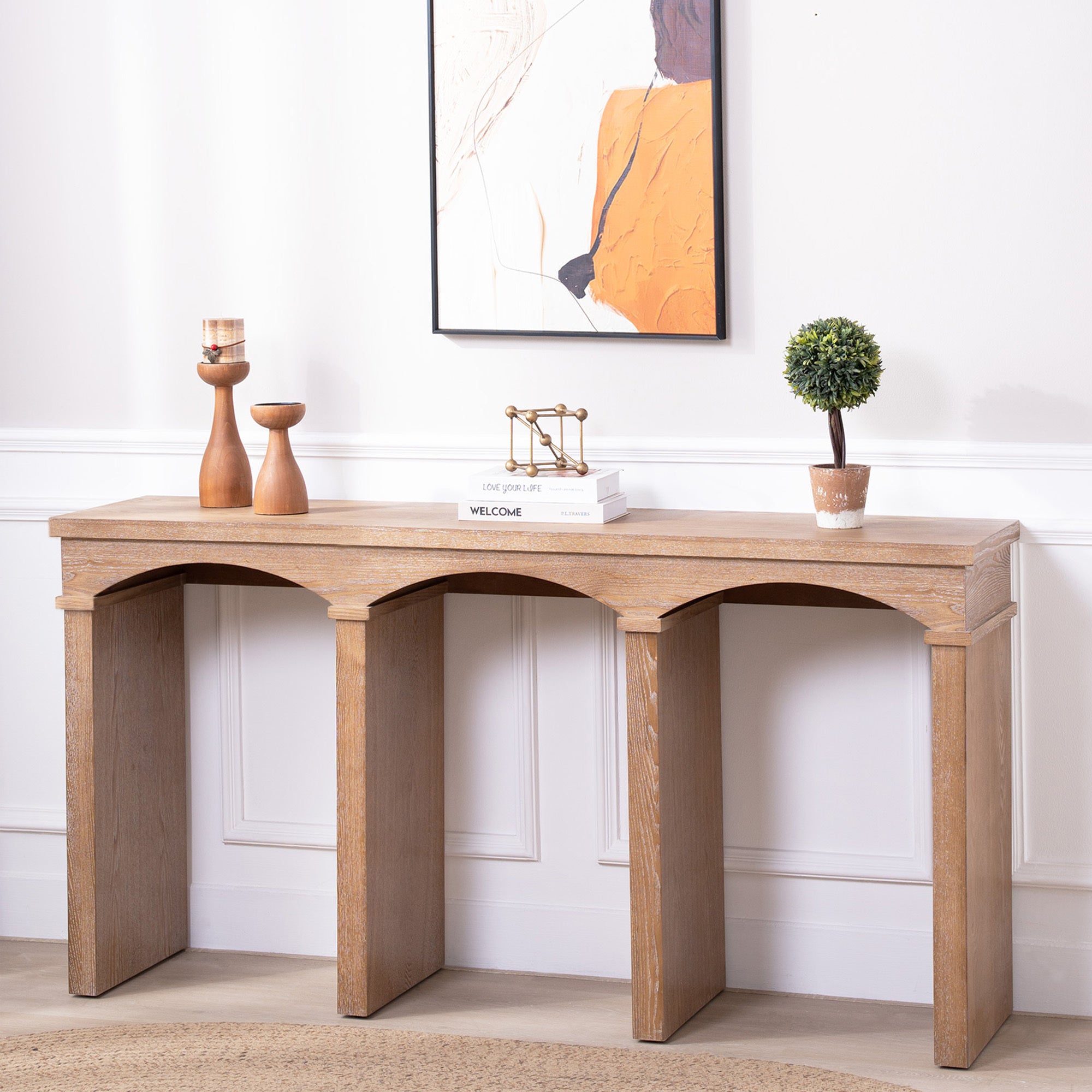 Natural wood finish console table with arched leg design, styled in a modern hallway with minimalist decor.