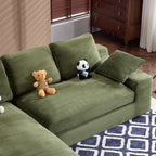 Green corduroy sofa with cushions and plush pillows, styled with teddy bears on a geometric rug, ideal for family-friendly interiors.