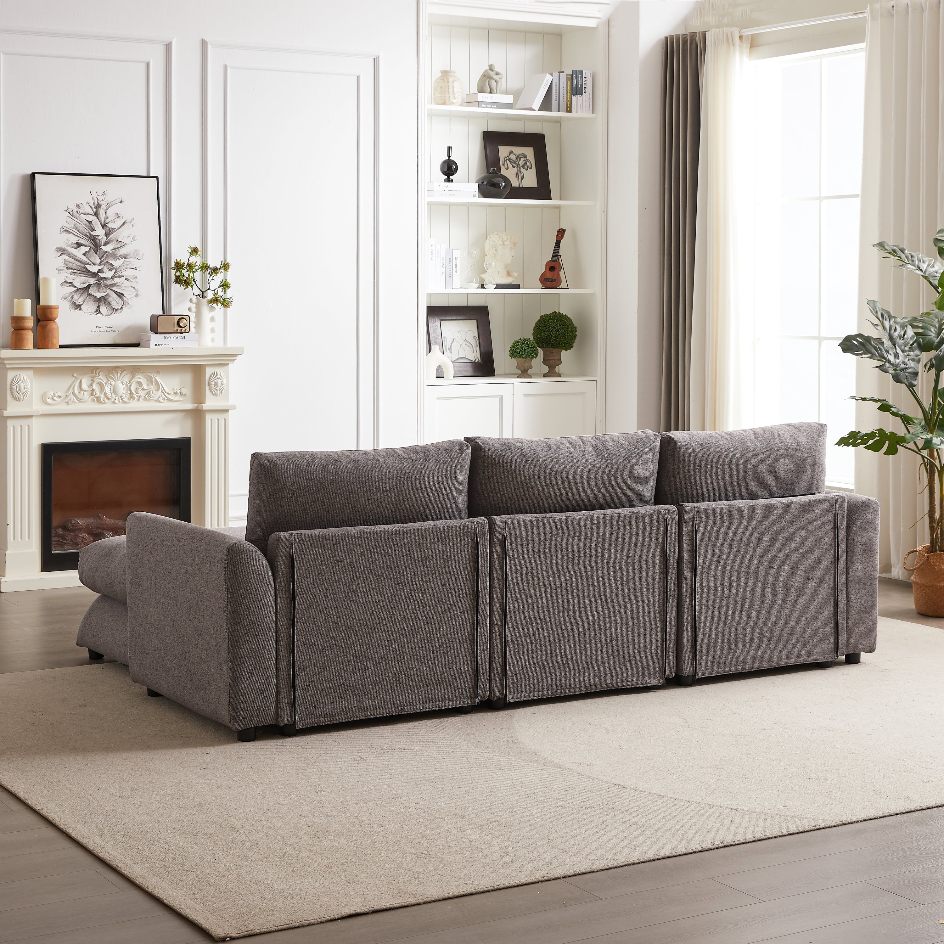 Rear view of modular sofa with ottoman, highlighting the clean lines and structured back panels of the upholstered furniture.