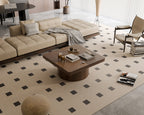 Modern living room featuring walnut square coffee table with parquet top and cylindrical base, centered on patterned rug.