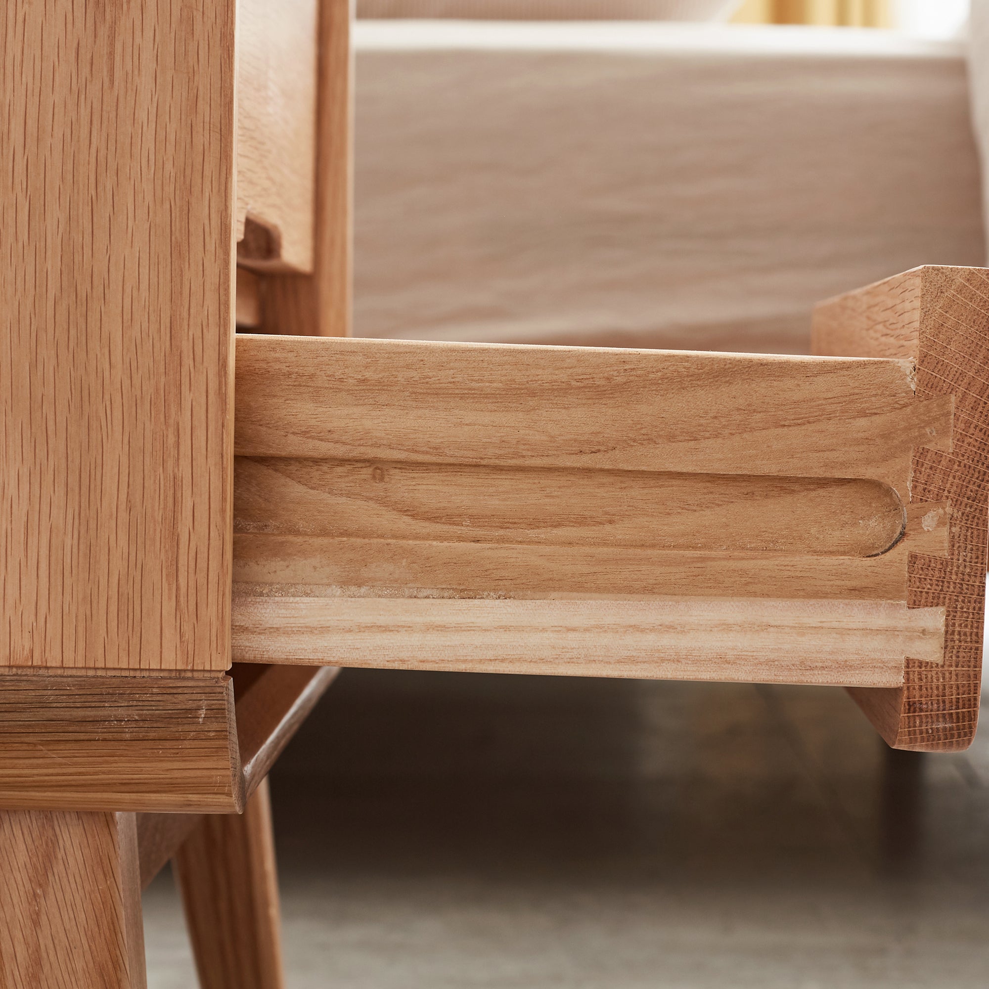 Solid Wood Bedside Cabinet - Organized Storage close-up of drawer rail and dovetail joint craftsmanship in oak wood.