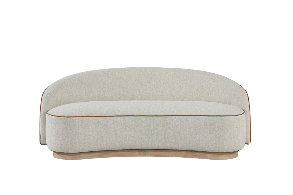 Curved beige tight-back sofa with brown piping detail on a light wood plinth base against a white background.