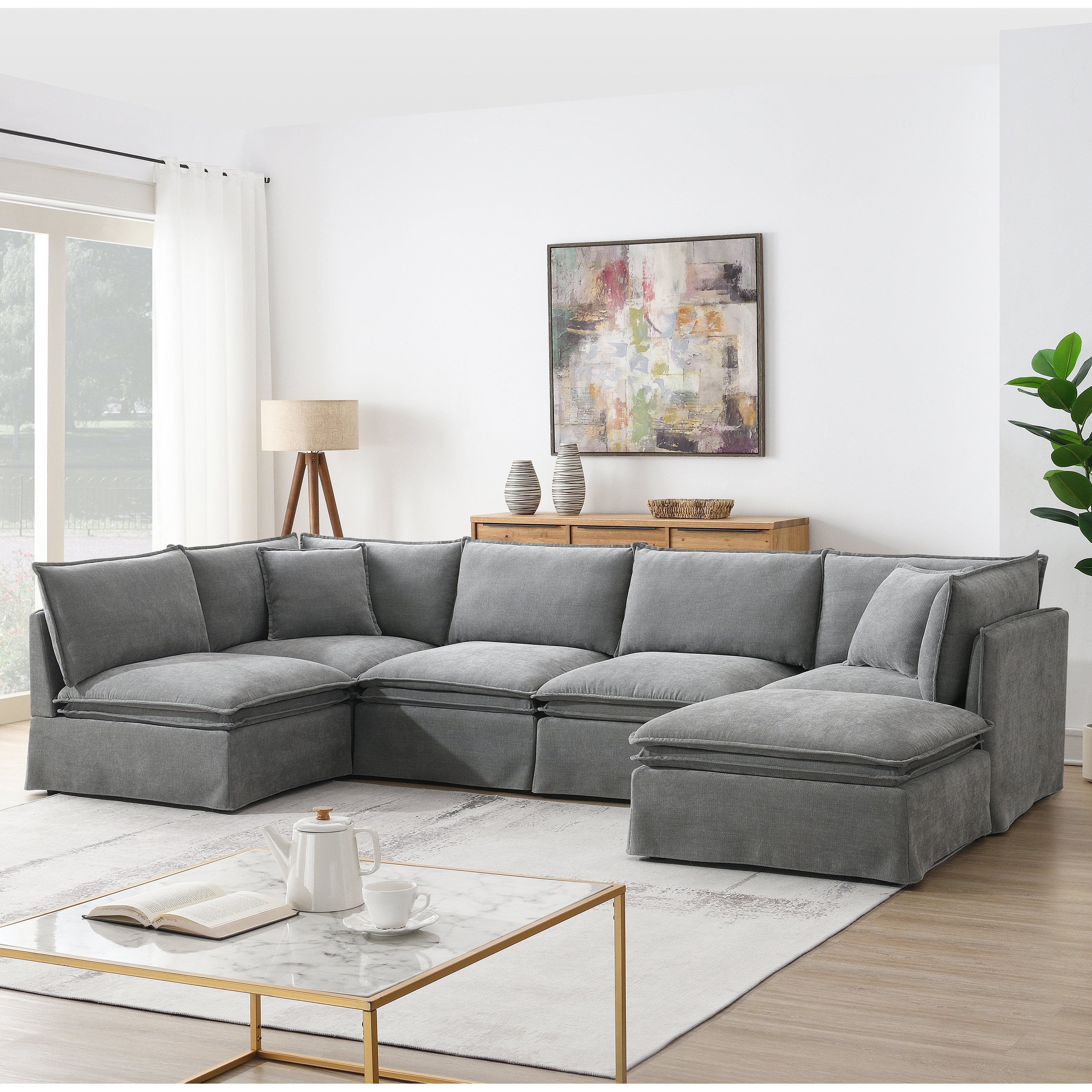 Gray 6-seat modular sectional sofa with movable ottoman in a bright living room, offering spacious comfort and modern style.