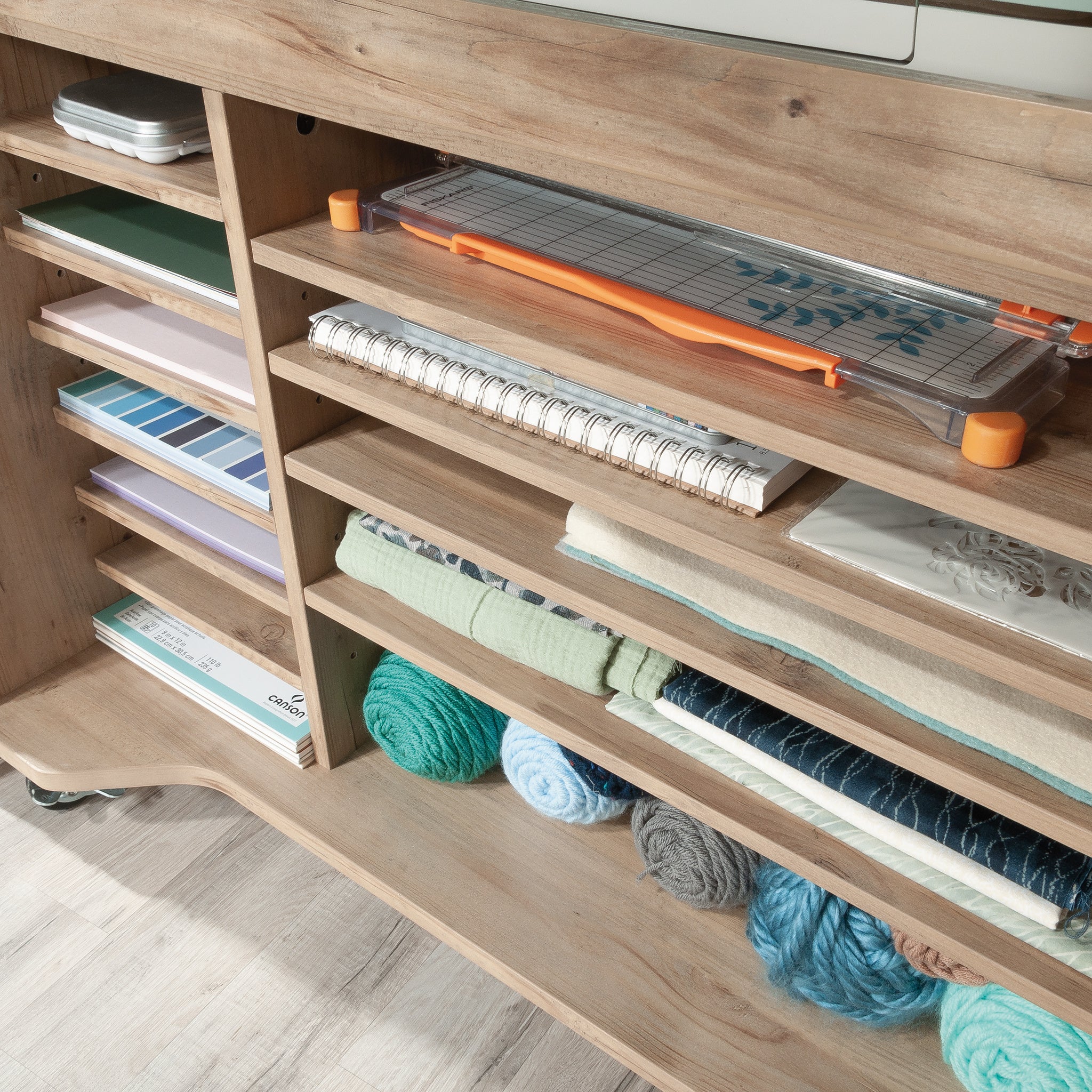 Interior shelves of Craft Cart with Storage for Home storing yarn, paper, and tools in organized cubbies and compartments.