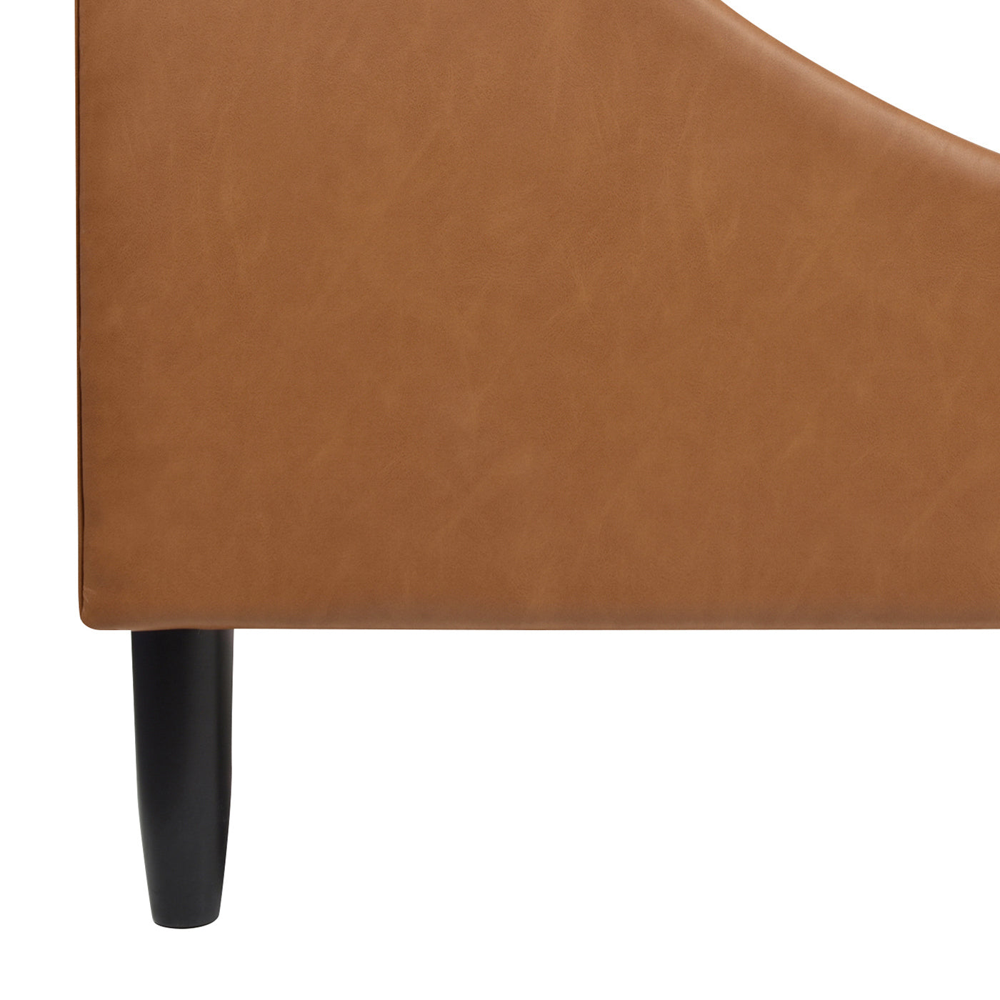 Close-up of caramel tan brown faux leather upholstery and black tapered leg on Aspen king platform bed frame.