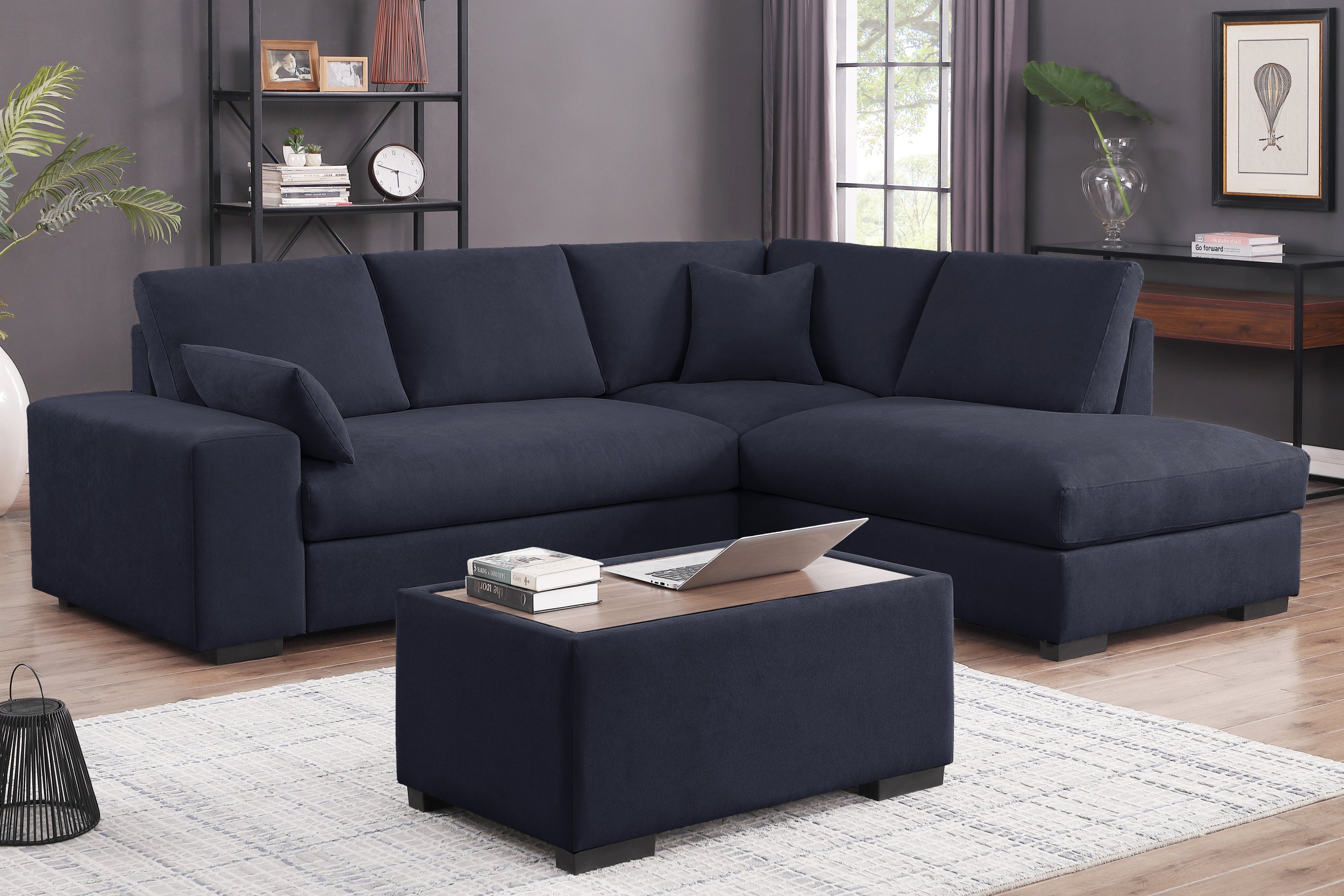 Dark gray sectional sofa with ottoman in modern living room. Fabric upholstery, chaise lounge, and seating for 4 with wood-top ottoman.