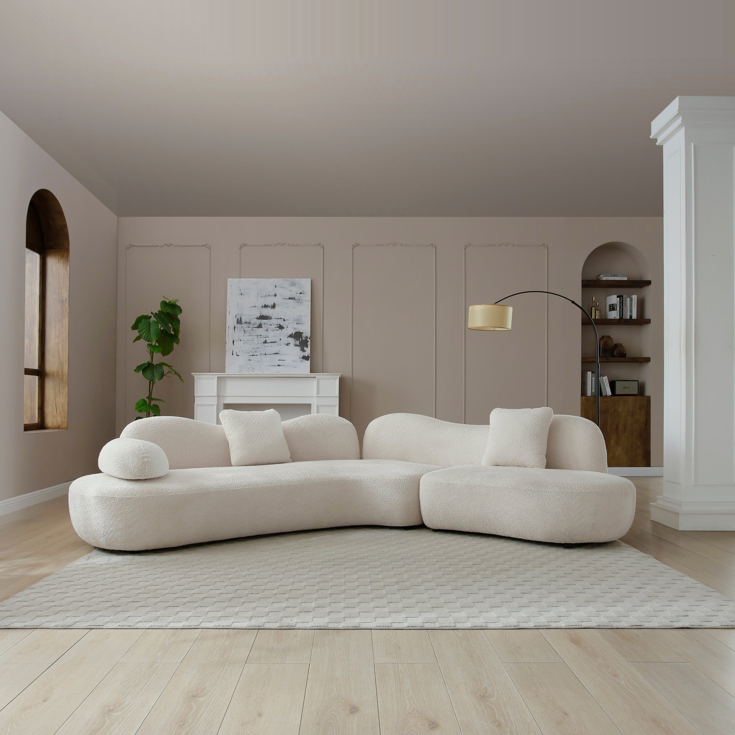 Curved sectional sofa in white boucle with solid wood frame, styled in a modern living room with neutral tones and minimalist decor.