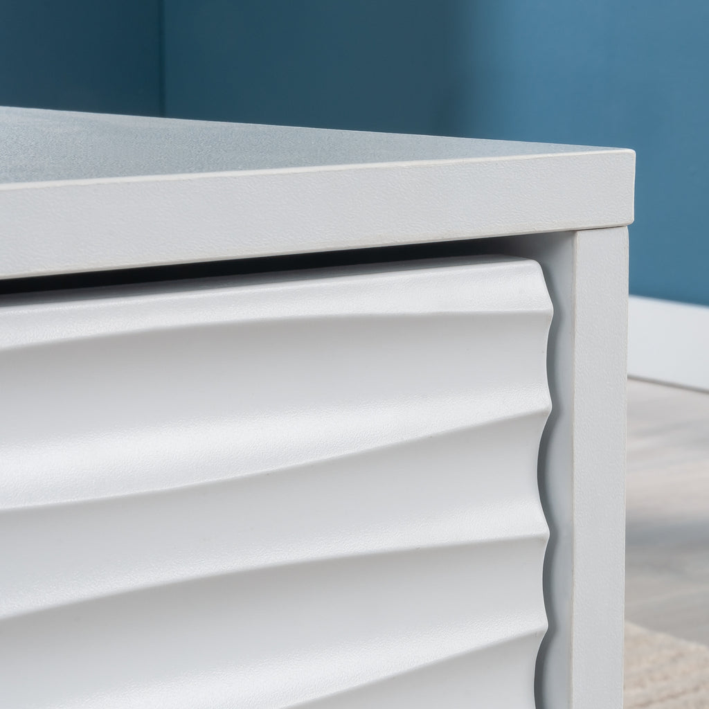 Detailed view of the wave-textured drawer front on the coastal style white coffee table, highlighting craftsmanship and design.