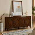 Mid-century walnut sideboard featuring four cabinet doors with symmetrical geometric carvings and tapered legs.