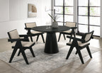 Jasper Dining Set - 5-Piece Ebony Black with pedestal base and fabric chairs in modern dining room. Ideal for contemporary interiors.