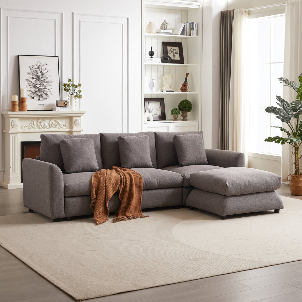 Modular sofa with ottoman in gray fabric, styled with a brown throw blanket in a bright, elegant living room setting.