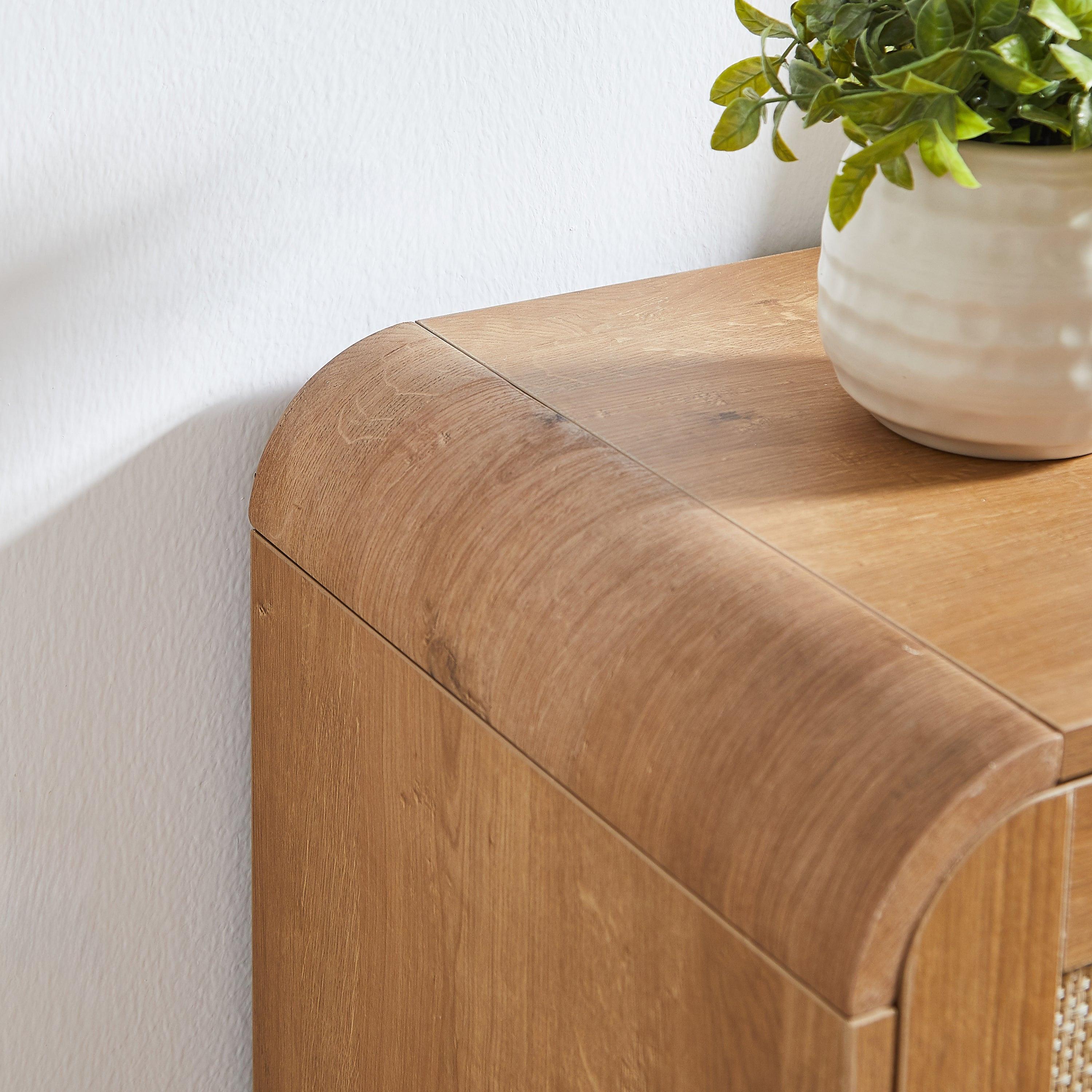 Rounded corner detail of rattan shoe cabinet in natural wood finish. Smooth edges enhance safety and modern design appeal.