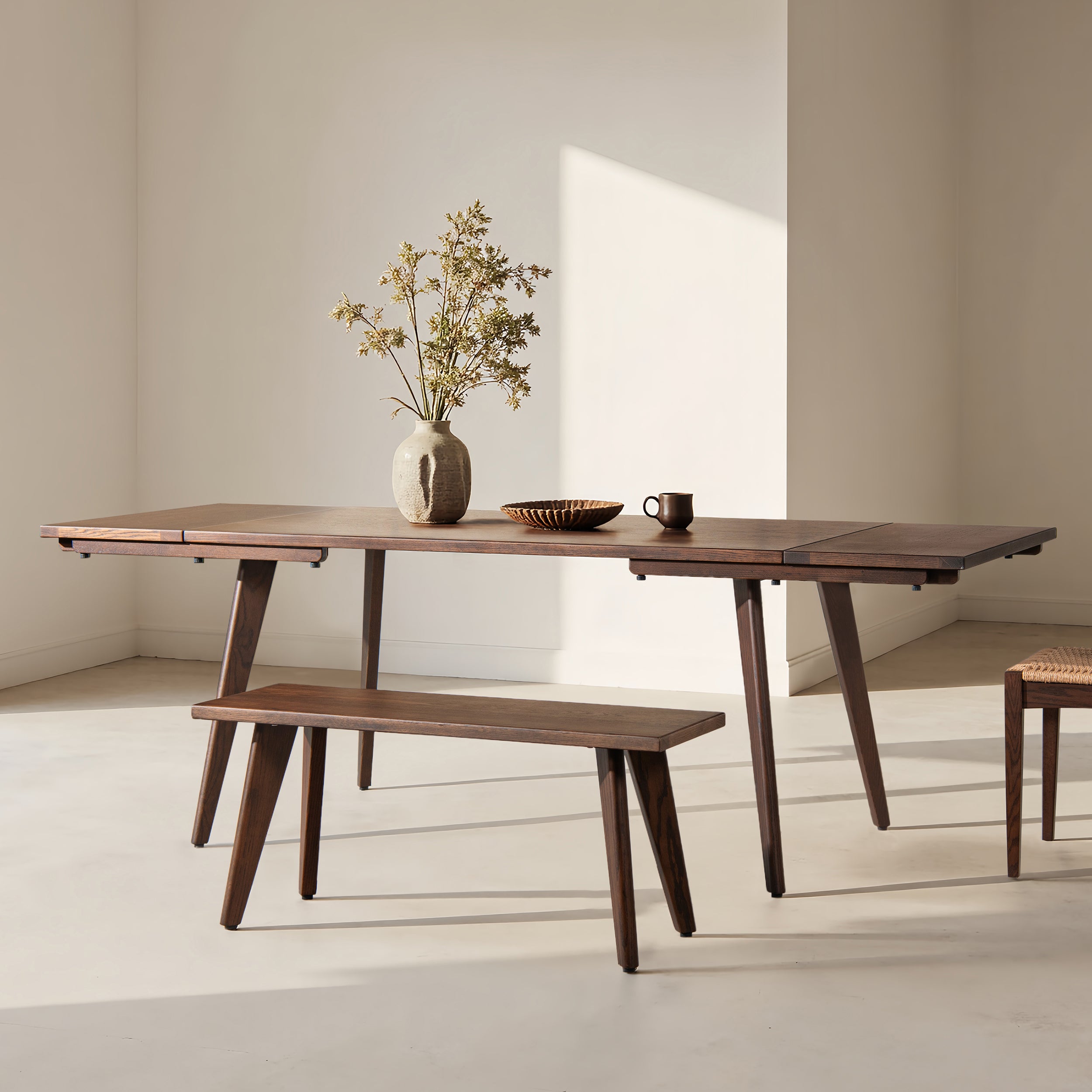 Capri 41.5' solid red oak wood bench in dark brown placed beside matching dining table in minimalist room. Ideal for kitchen or dining use.