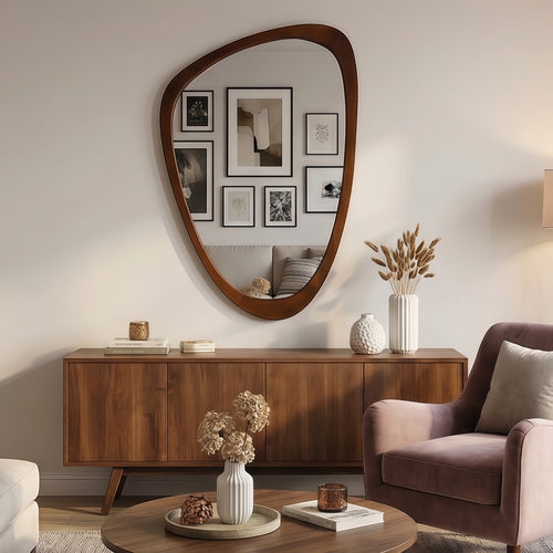 Irregular walnut-finished wooden mirror with a modern organic frame shape, mounted above a mid-century sideboard.