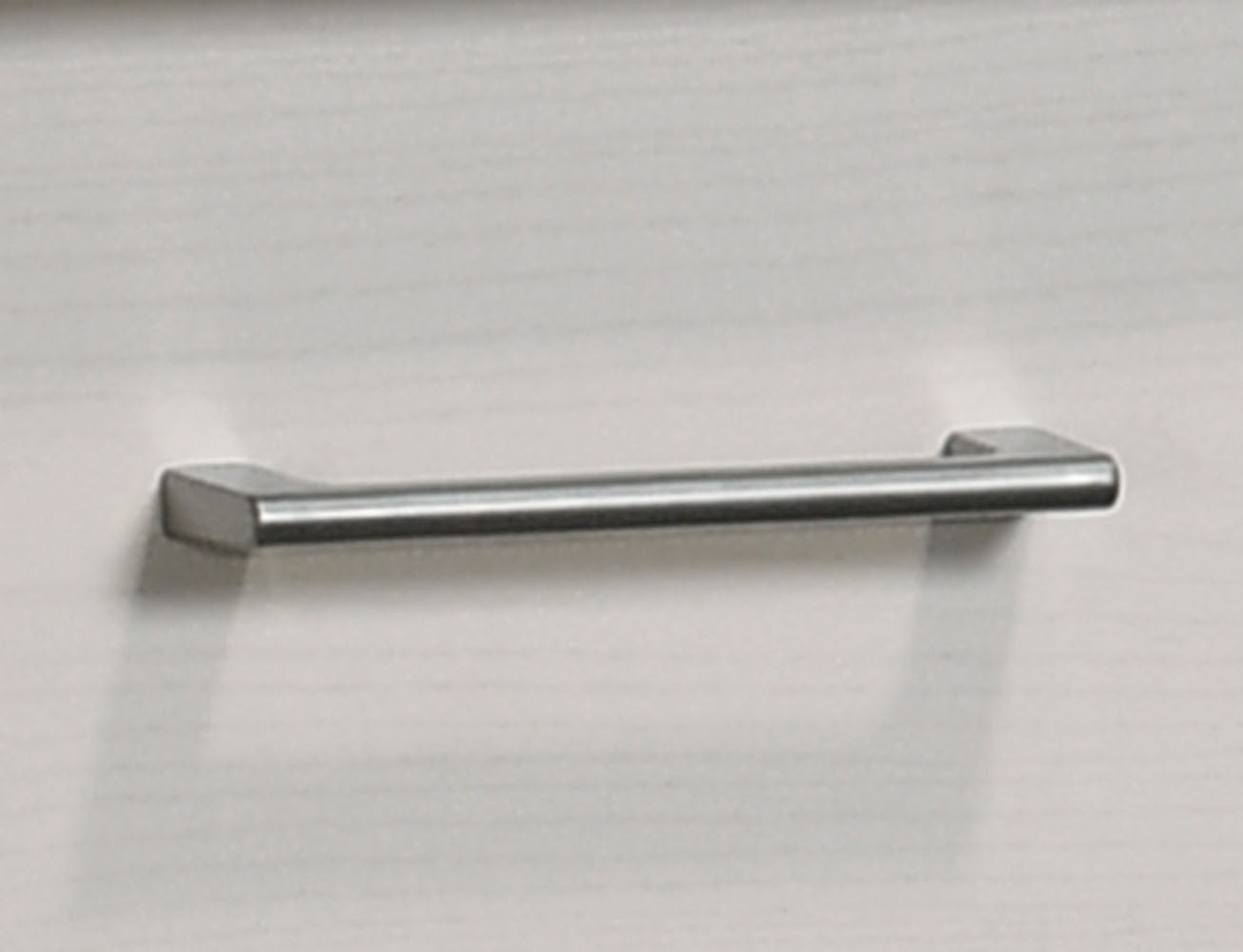 Close-up of metal handle on Celeste White Nightstand drawer. Modern hardware complements sleek, minimalist design.