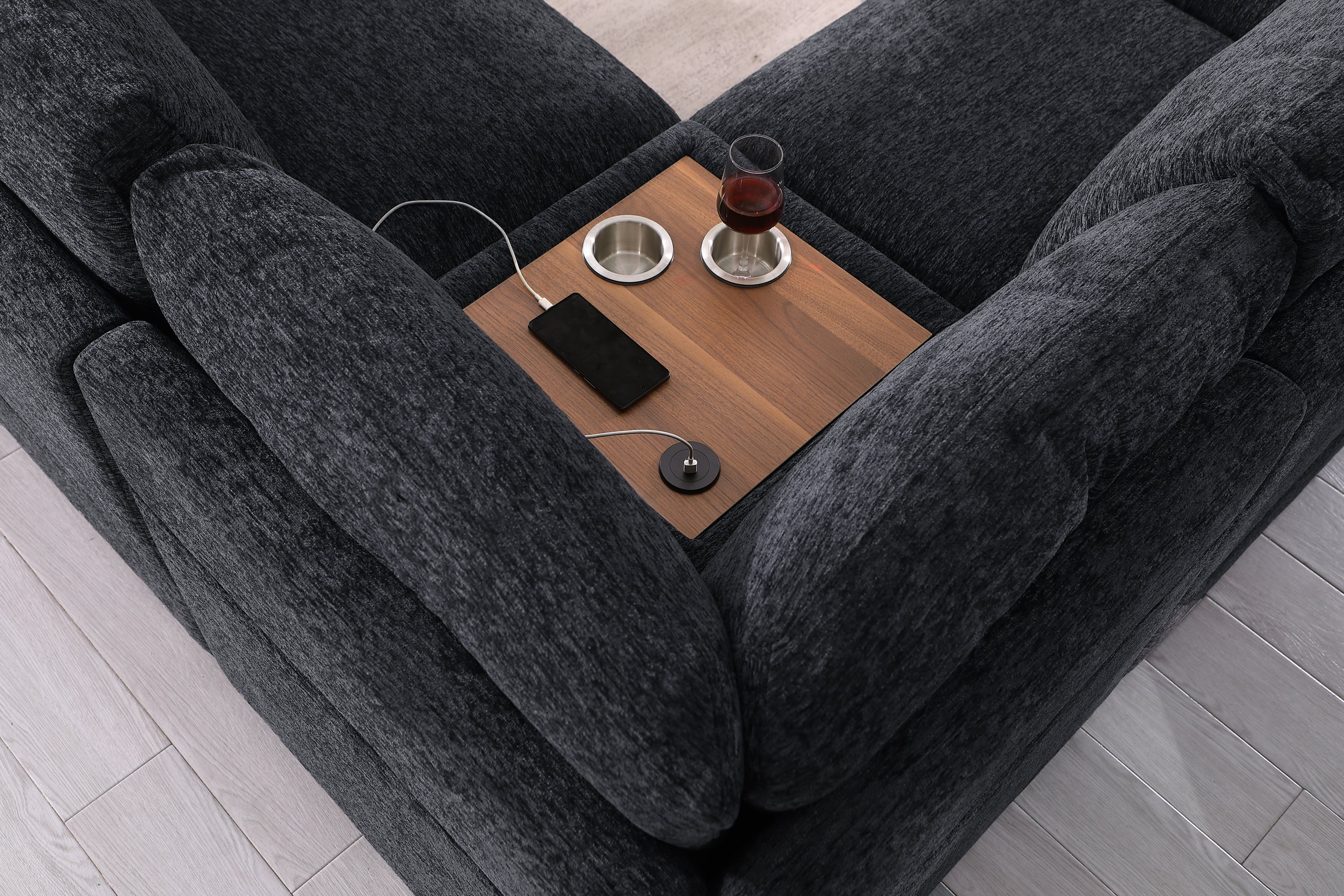 Top view of Celine sectional sofa's wooden tray with USB port and cupholders. Dark gray fabric and smart living room features.