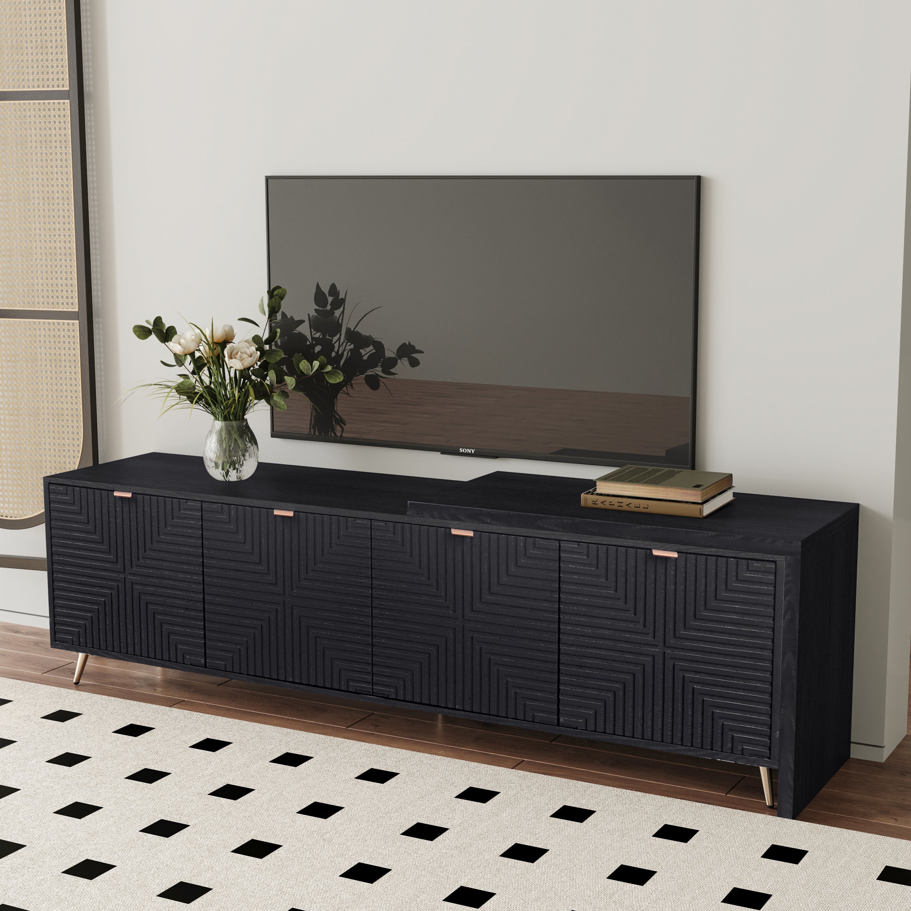 70'-90' extendable black media console with modern textured finish, supporting a flat-screen TV and decorative vase in a stylish interior.