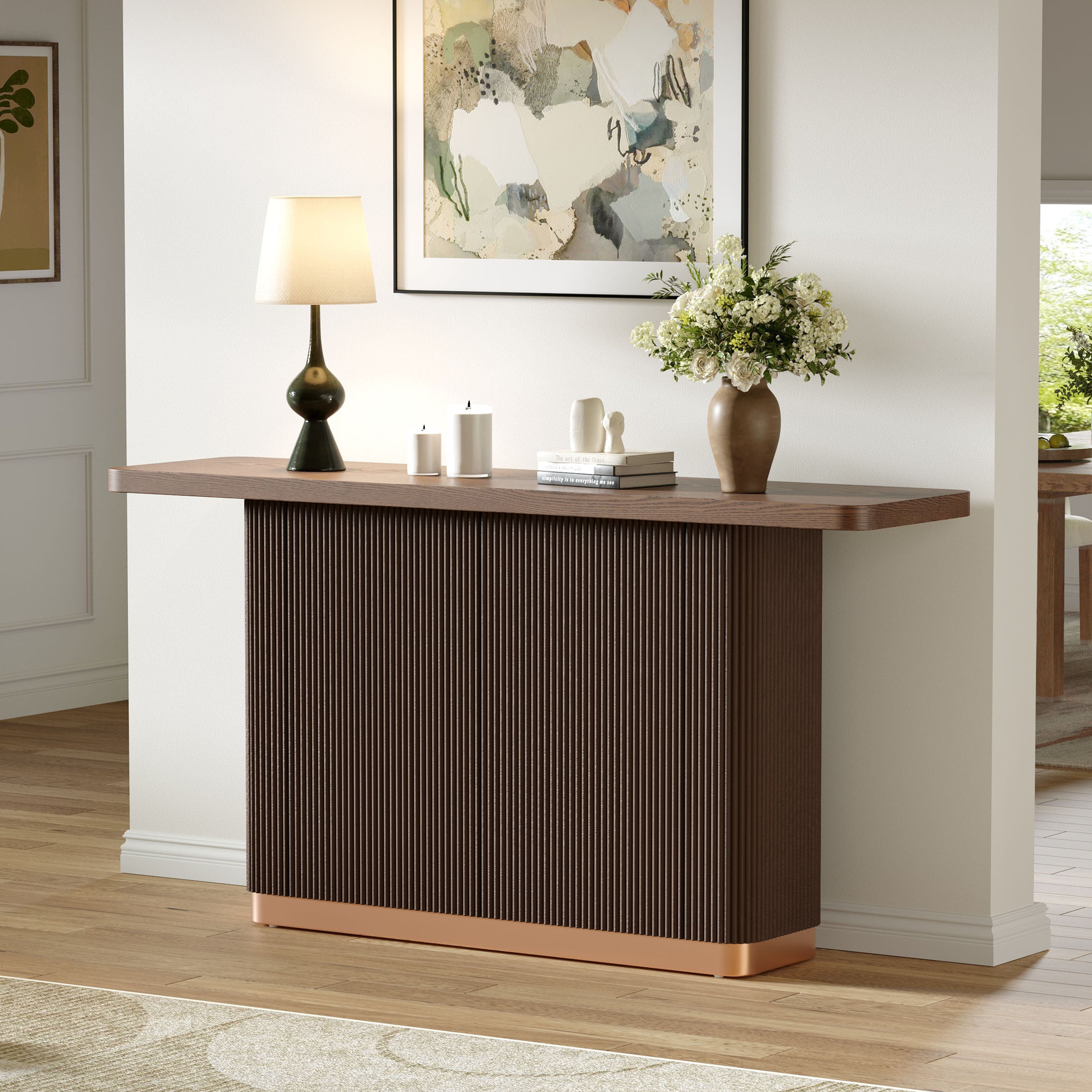 Modern console table with ash veneer top and metal accent styled in entryway. Features ribbed wood texture and sleek copper base.