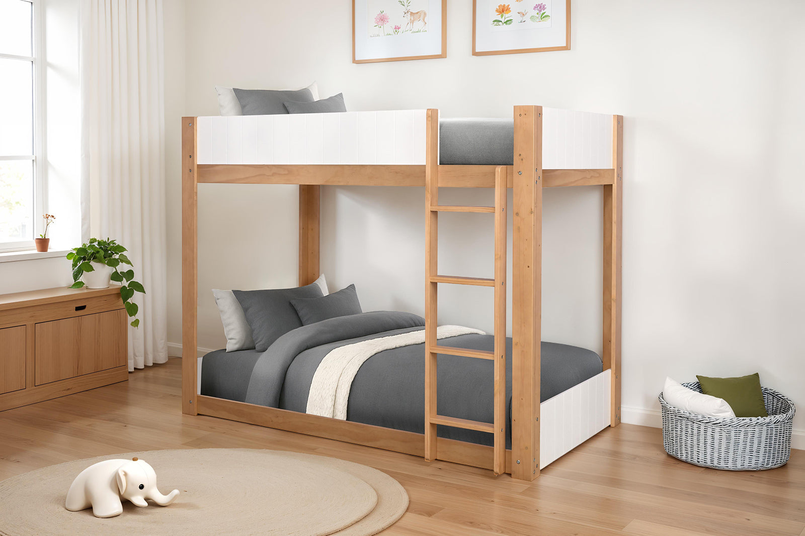 Twin over twin bunk bed with ladder in white and natural wood finish, placed in a modern kids' bedroom with gray bedding and wall art.