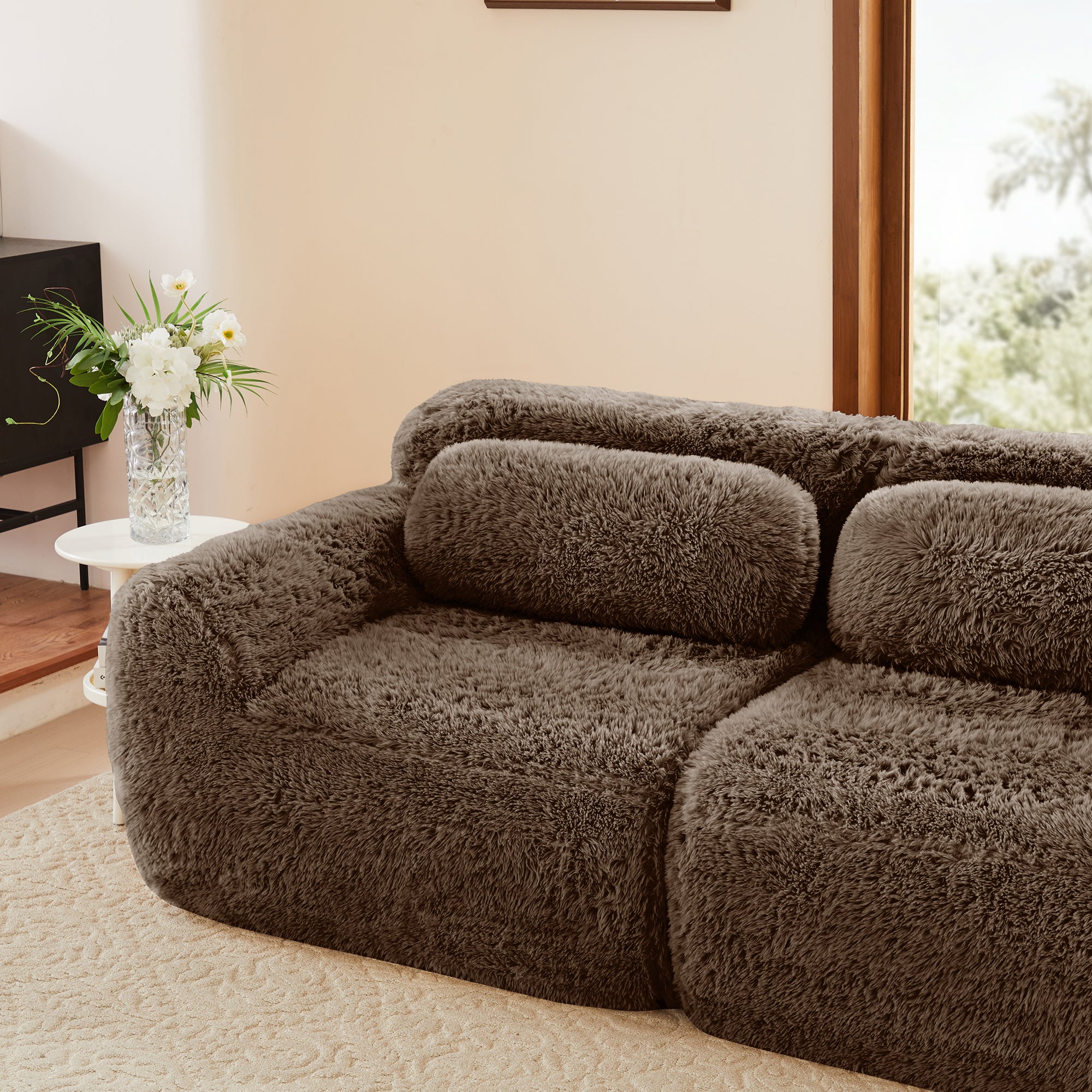 Side view of plush chocolate L-shaped modular sofa in a cozy living room. Ergonomic design with no assembly and soft, inviting texture.