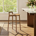 Single Sven 30' modern low back barstool in dark brown walnut ash wood near a marble kitchen island with natural light.