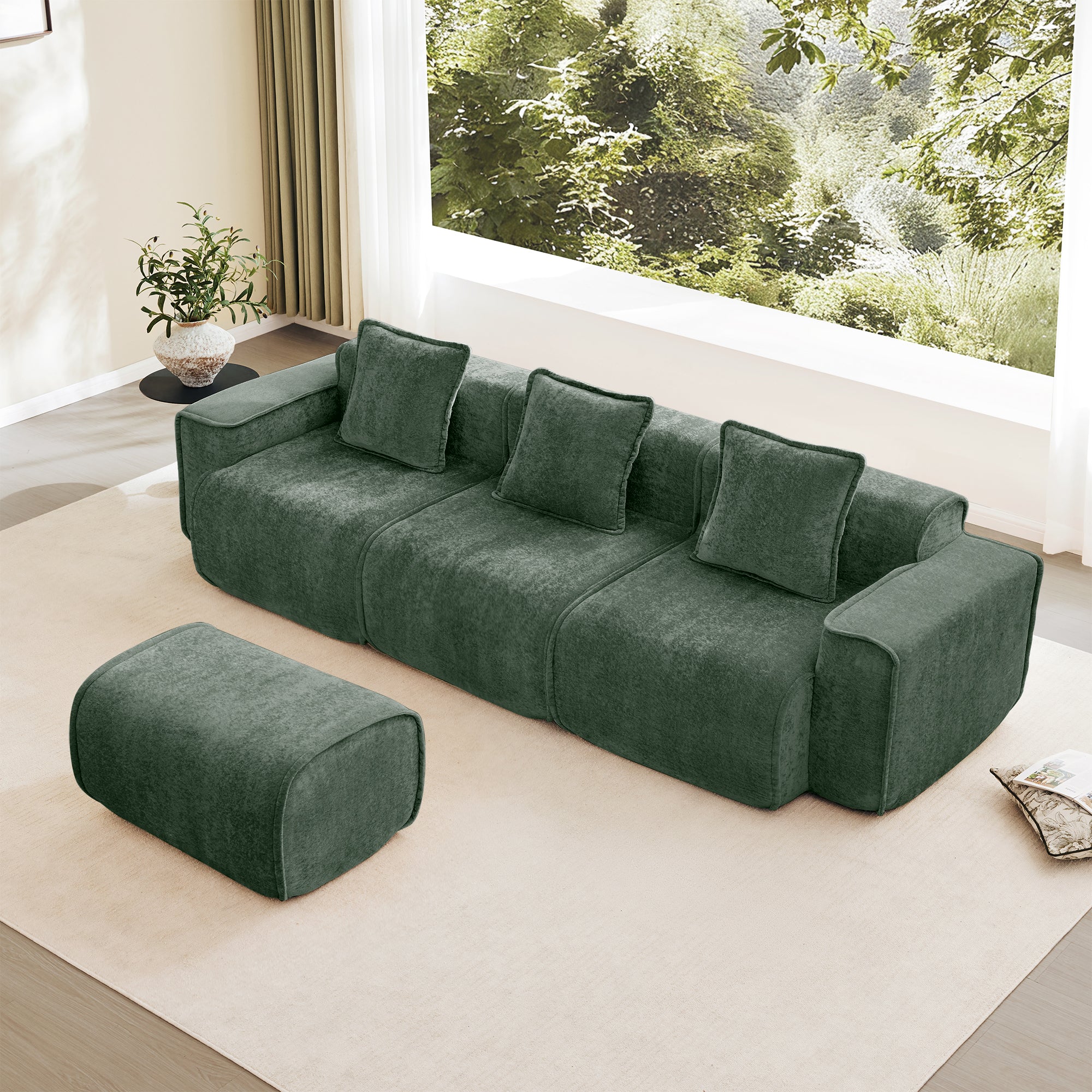 Luxurious green velvet modular sofa with ottoman, French piping detail, and plush cushions in a bright, minimalist room.