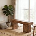 Rustic solid wood bench with a chunky, minimalist design and natural grain finish on a jute rug by a bright window.