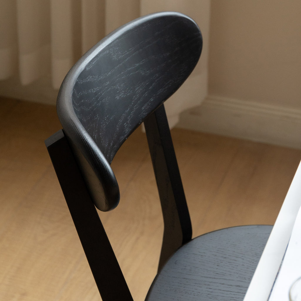 Close-up of curved backrest on Solid Oak Dining Chair in black, emphasizing its smooth finish and ergonomic design.