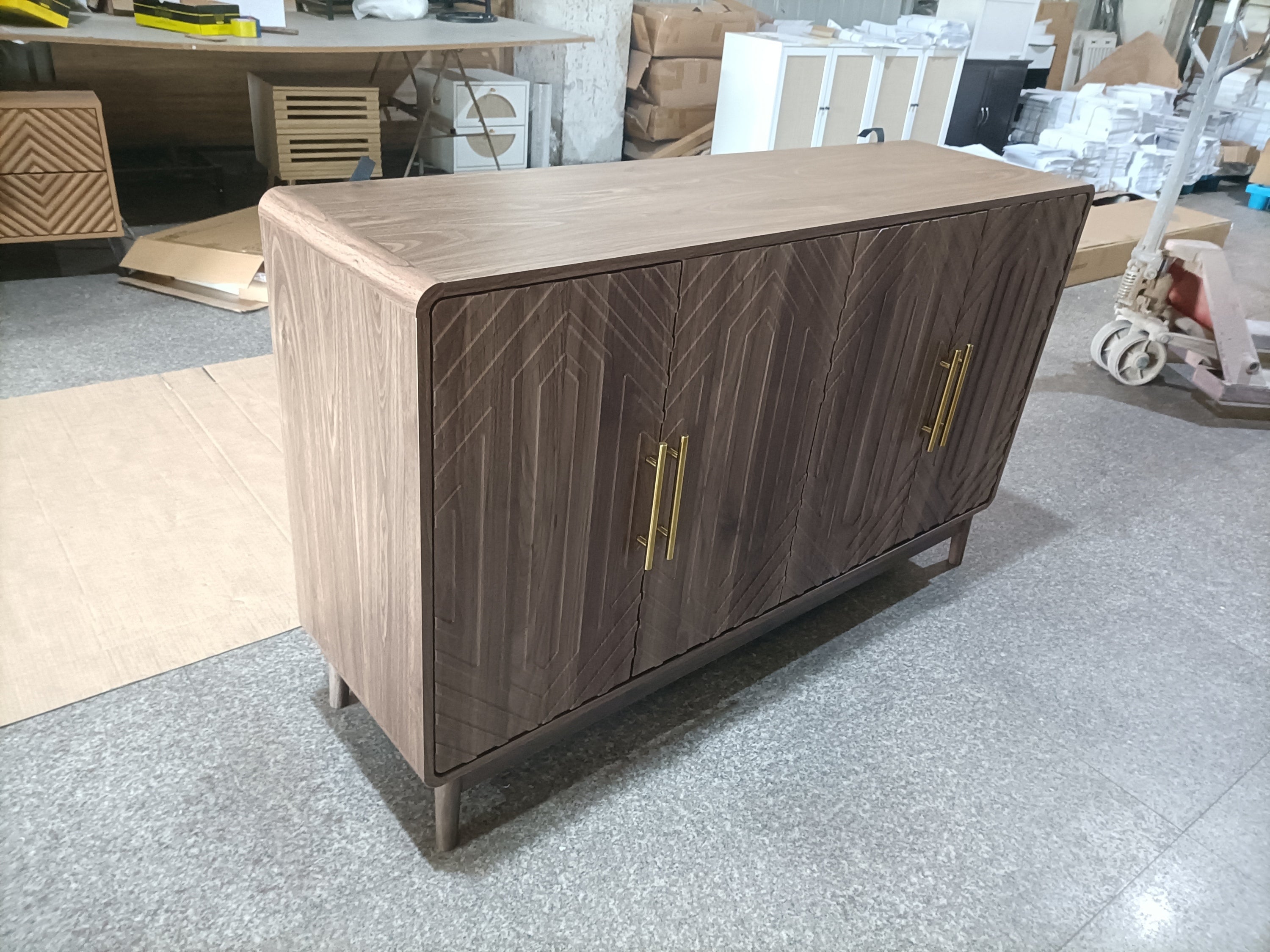 Angled view of walnut sideboard with gold handles and decorative wood pattern, highlighting its modern and elegant design.