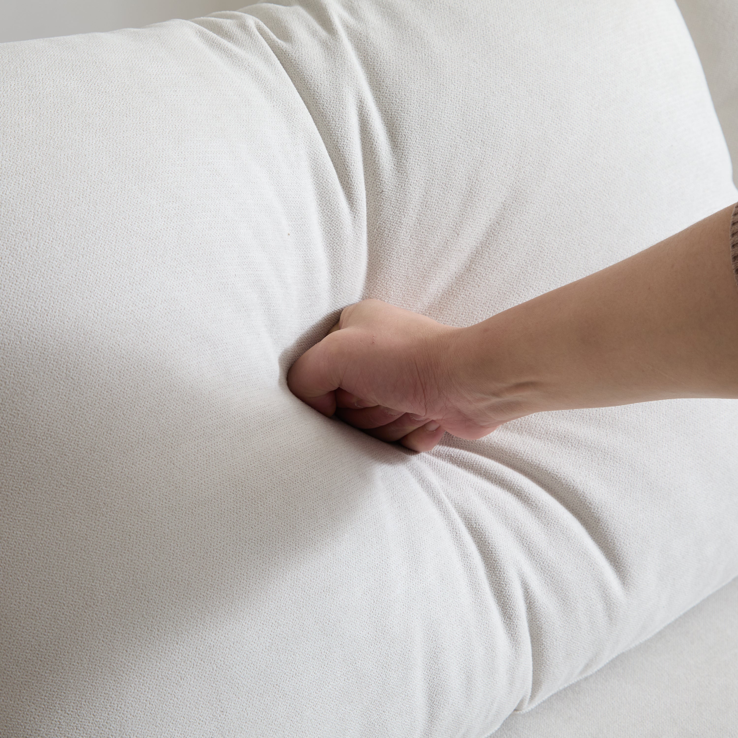 Close-up of cushion firmness test on 69 in. 2-Seats Modular Sectional Sofa Corner Chair Sofa Couch in white fabric upholstery.