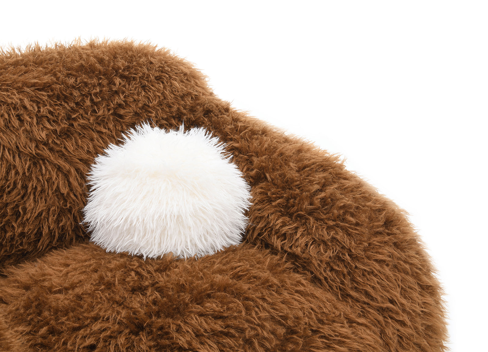 Detail of the Camel Brown Swivel Chair showing the included white faux fur pillow nestled in the plush seat for added comfort.